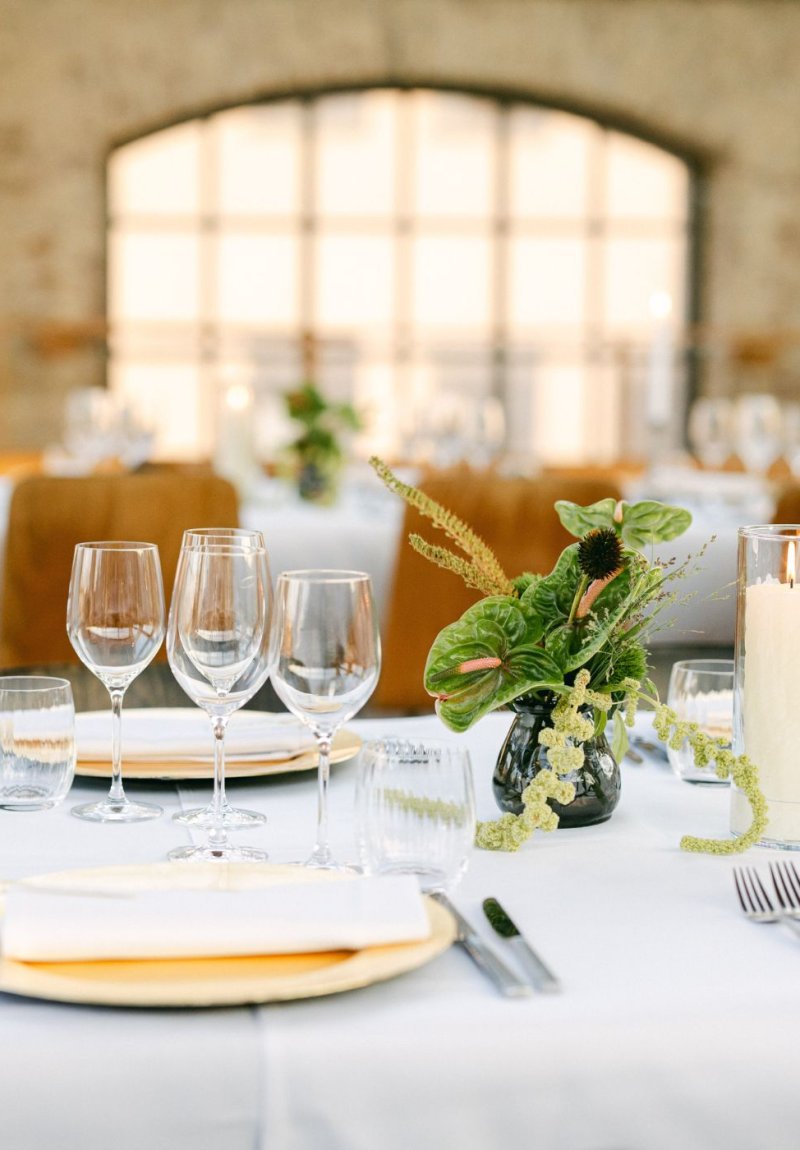 Table élégamment dressée pour un événement avec verres, bougies et plats – Service traiteur Bruxelles.